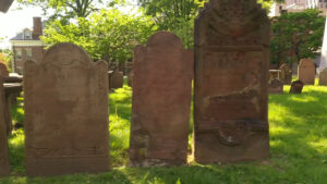 Aerial Drone footage frame of Ancient Burying Ground Hartford - down line of brown/red stone gravestones